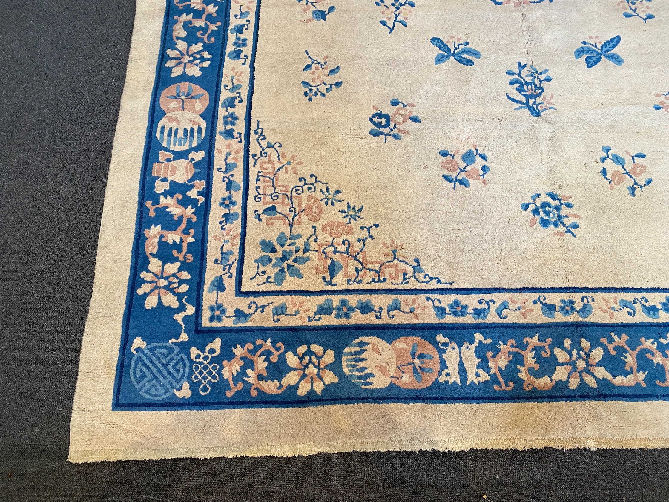 A Chinese ivory ground carpet with scattered floral field 368 x 284 cms